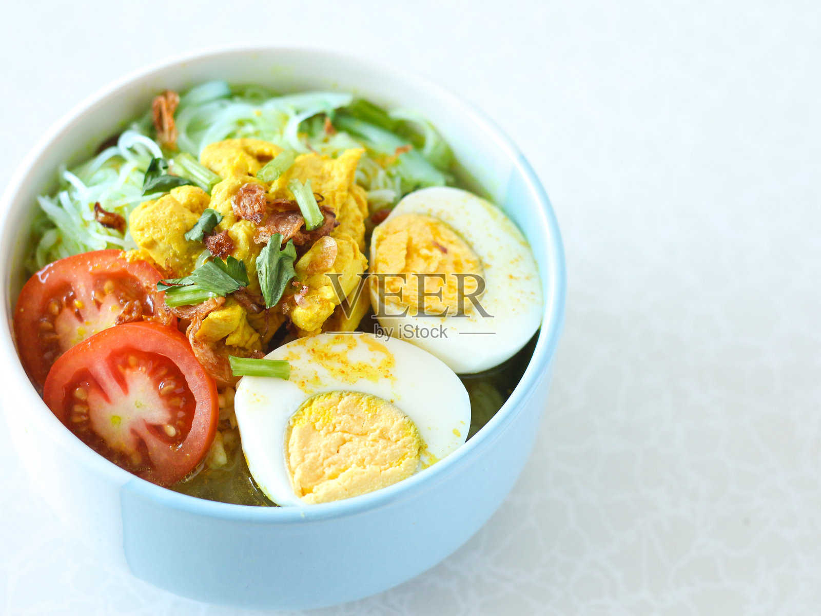 Soto ayam或印尼黄色汤面条和鸡蛋。照片摄影图片