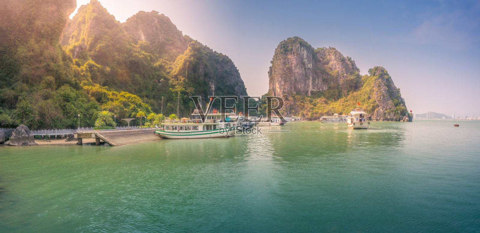 越南广宁省下龙湾景观;有很多石灰岩小岛和游轮;在一个蓝天的夏日照片摄影图片