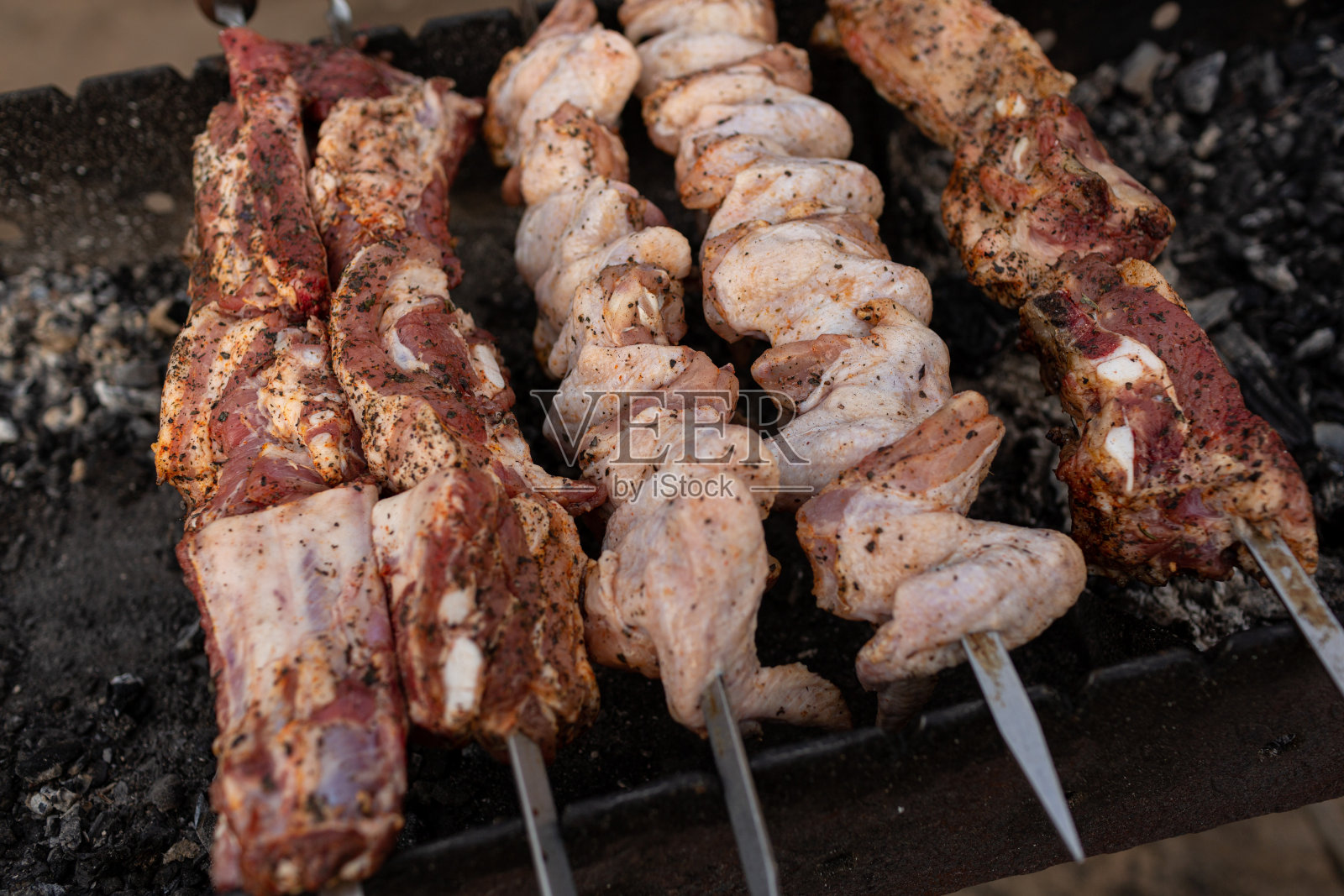 肉块和鸡翅串在烤串上照片摄影图片