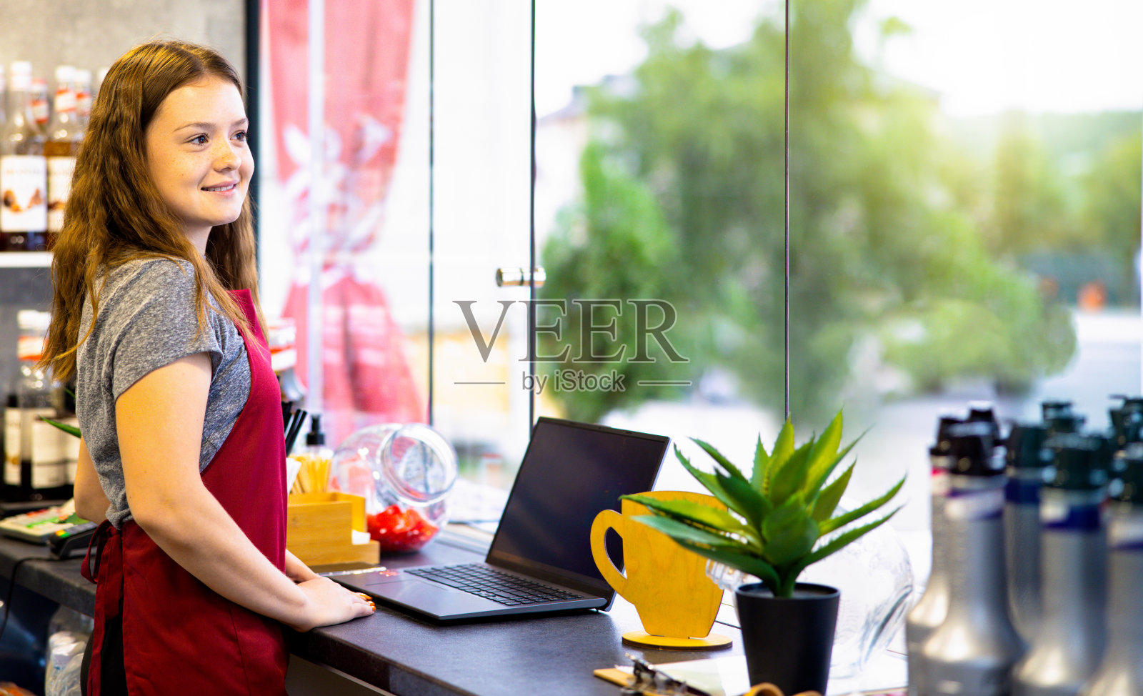 美丽的女孩有一个美好的时间和早上喝卡布奇诺在漂亮的咖啡店坐在木桌。照片摄影图片