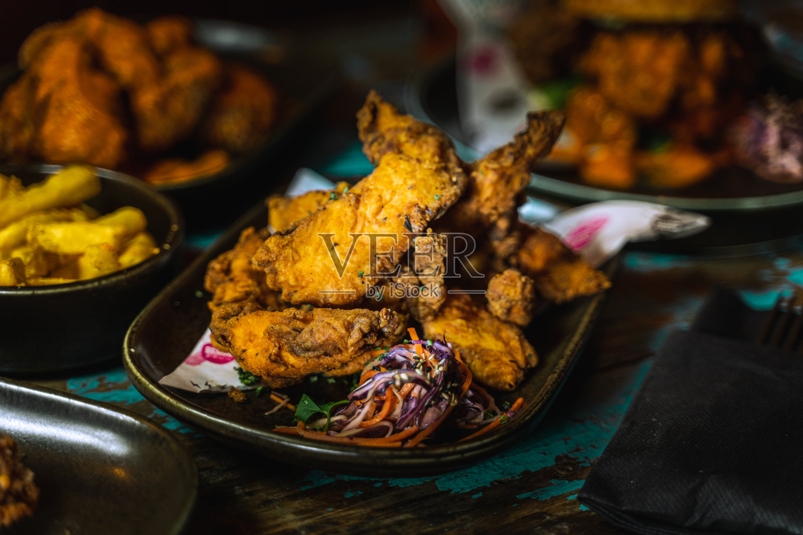 鸡肉汉堡和鸡翅在黑暗肮脏的餐厅设置照片摄影图片