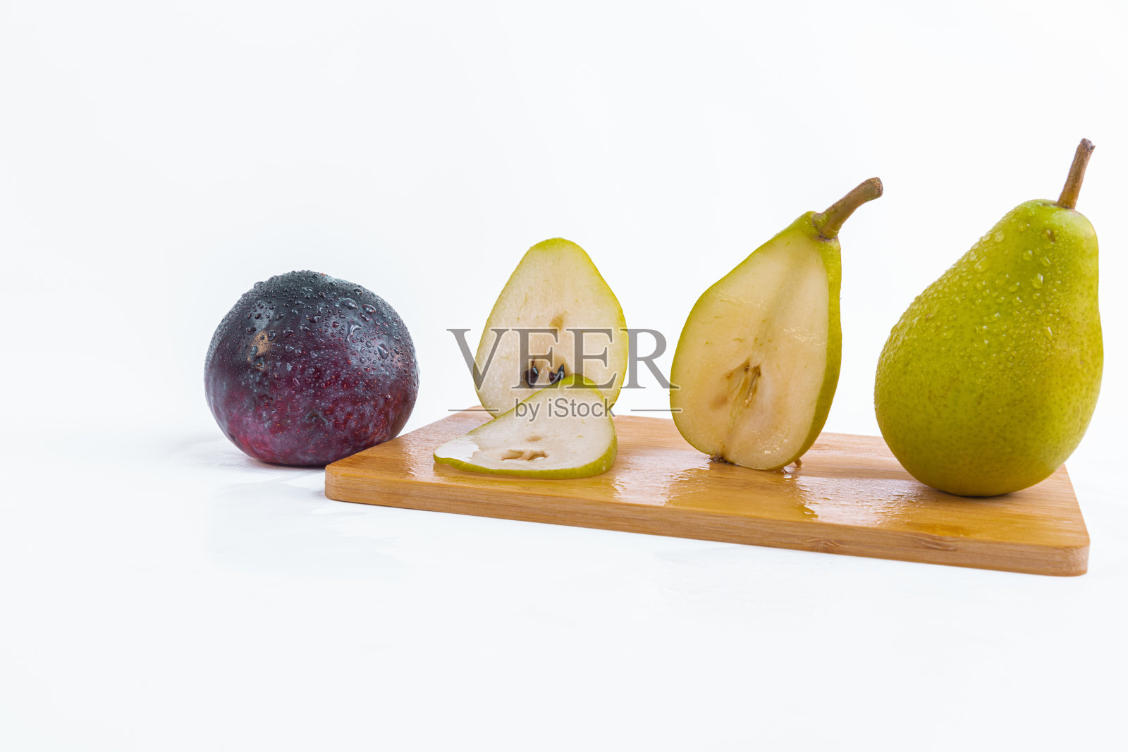 白色背景上木板上的新鲜梨和李子特写照片摄影图片