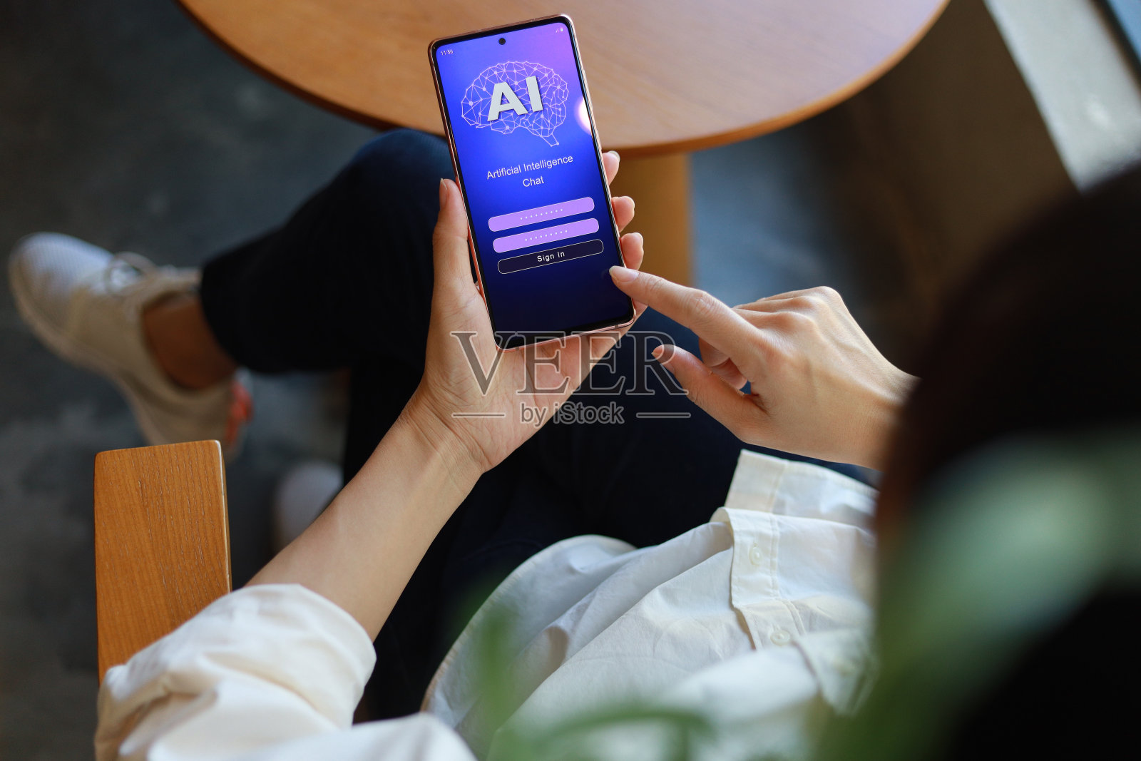 一名女子正在用她的手机登录并与人工智能聊天机器人聊天。这款机器人应用代表了全球连接和人工智能技术的最新创新照片摄影图片
