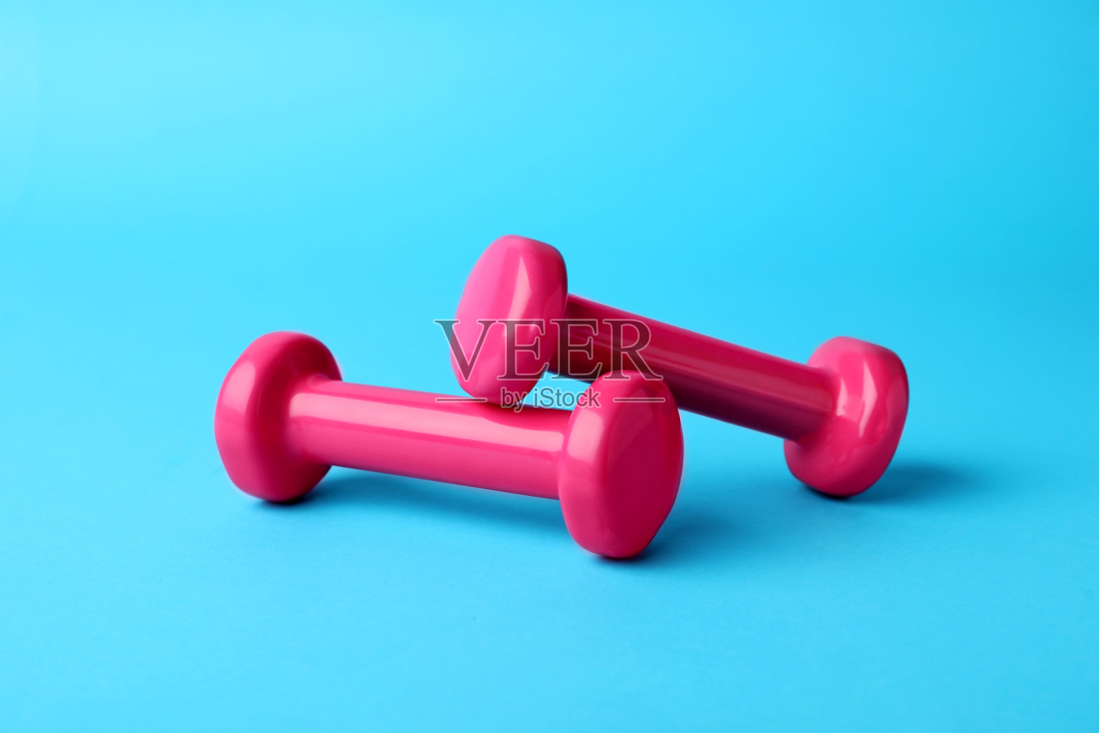 两个时尚的哑铃在浅蓝色的背景照片摄影图片