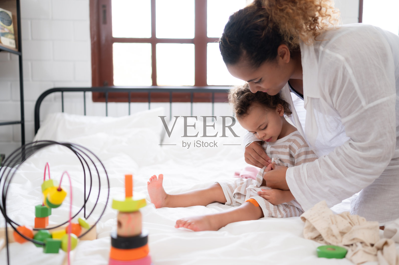 妈妈和小女孩一起在卧室里玩你的新玩具。增强儿童思维能力的玩具。照片摄影图片