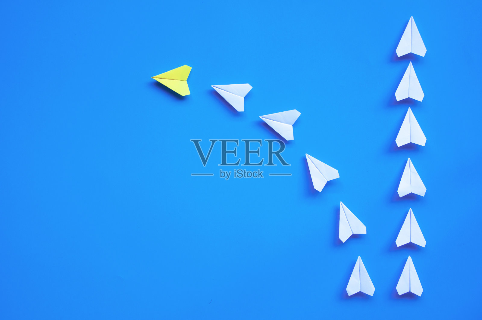 黄色纸飞机折纸引领其他白色飞机在蓝色背景与自定义空间的文字或想法的俯视图。领导技能的概念和复制空间照片摄影图片