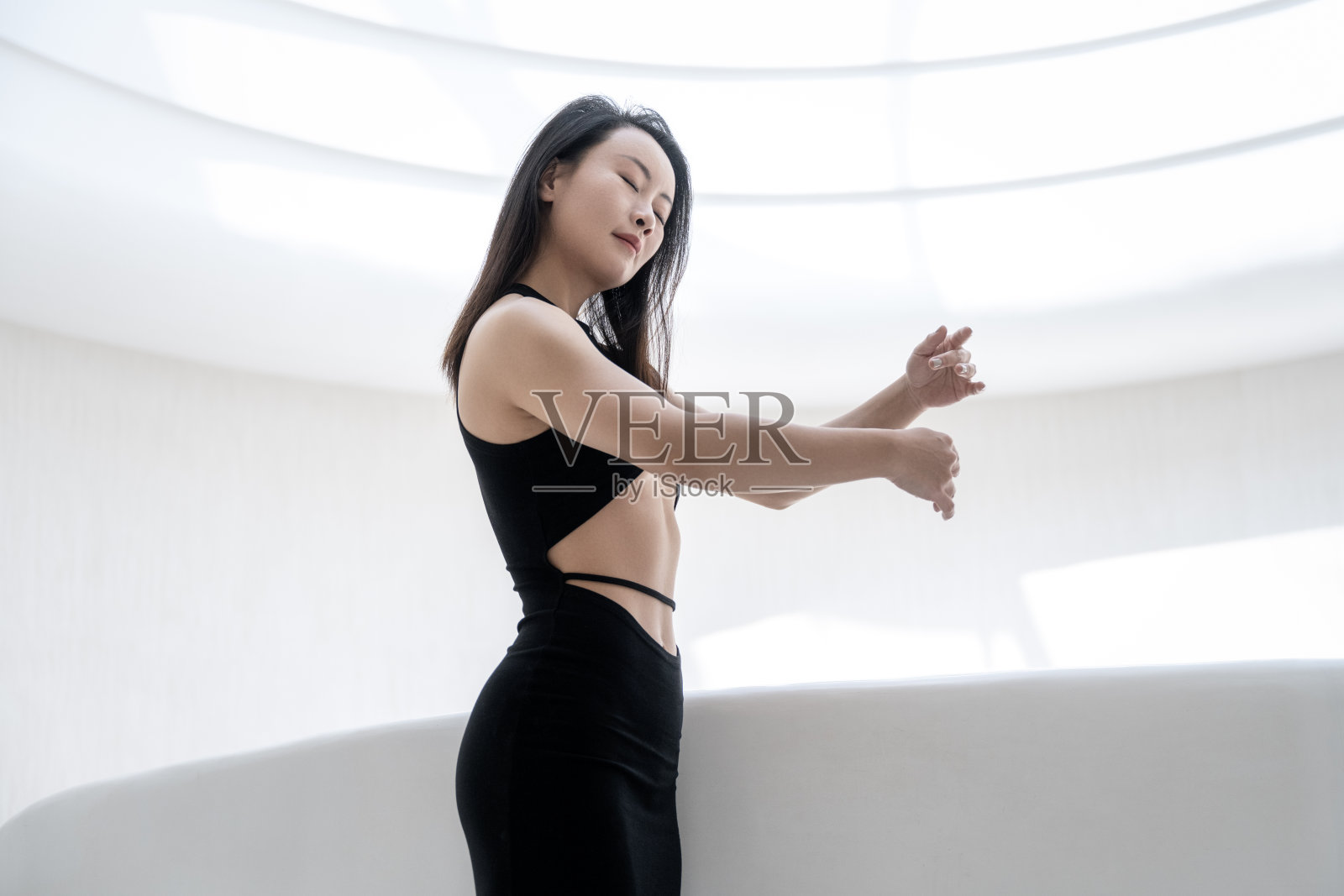 穿着黑色运动服的妇女靠在栅栏上照片摄影图片