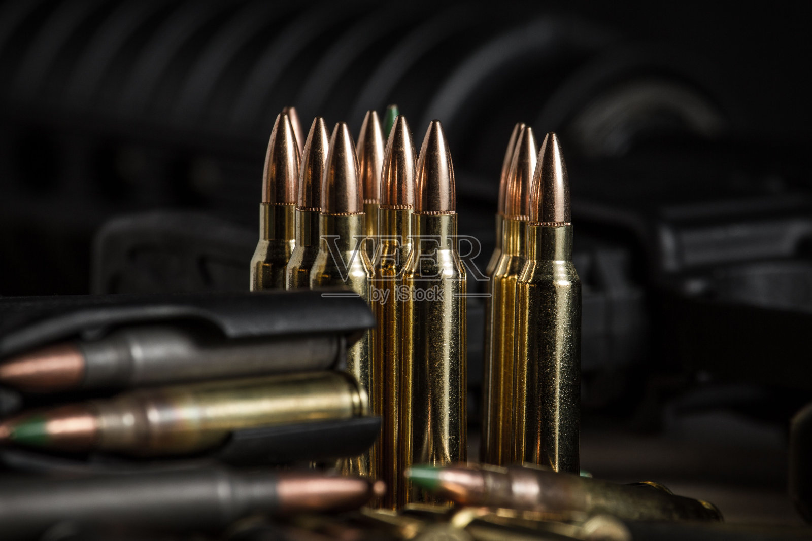 223发步枪子弹放在或放在一个装满子弹的AR-15弹匣旁边照片摄影图片