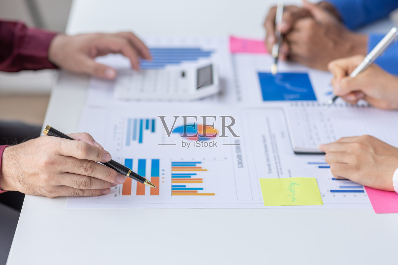 一群自信的商业人士指着图表和图表来分析市场数据、资产负债表、账目、净利润,以计划新的销售策略来增加产能。照片摄影图片