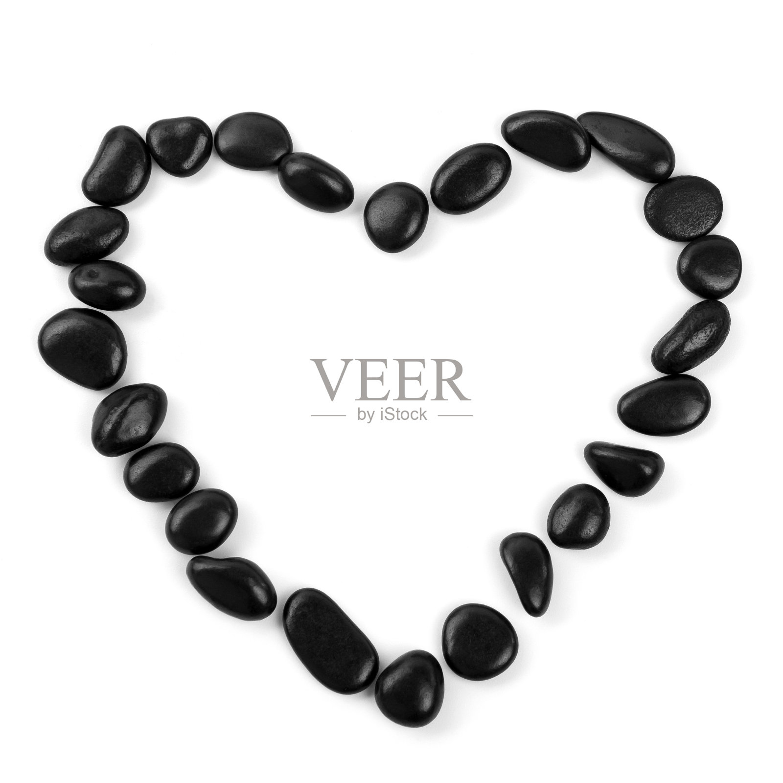 黑色的石头把心孤立在白色的背景上。照片摄影图片