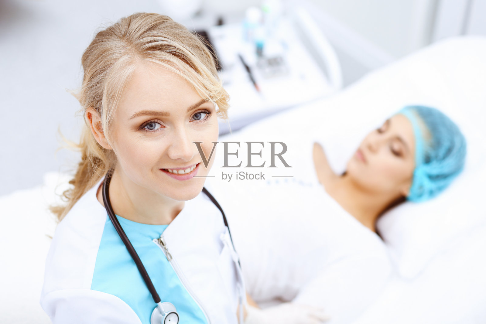 女医生和年轻女病人在医院。医生检查躺在床上的女孩,从上面看照片摄影图片