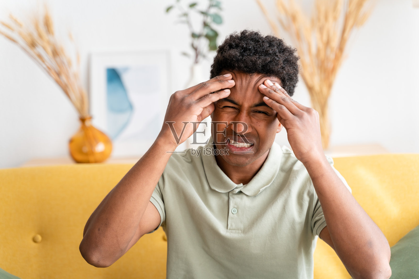 开朗的黑人捂着眼睛,头痛不已照片摄影图片