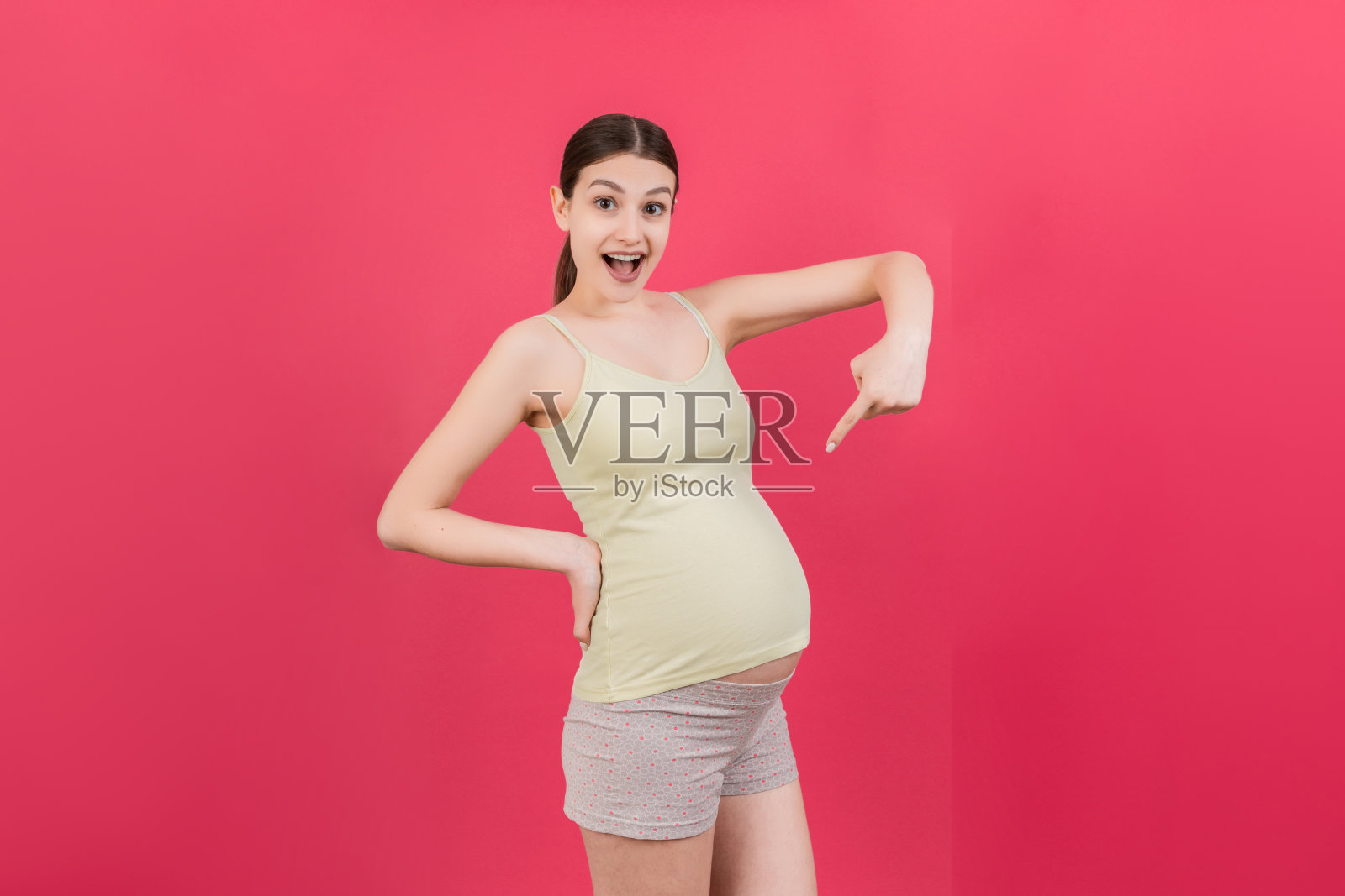 年轻惊讶或震惊的孕妇孤立的彩色背景。表达女性照片摄影图片