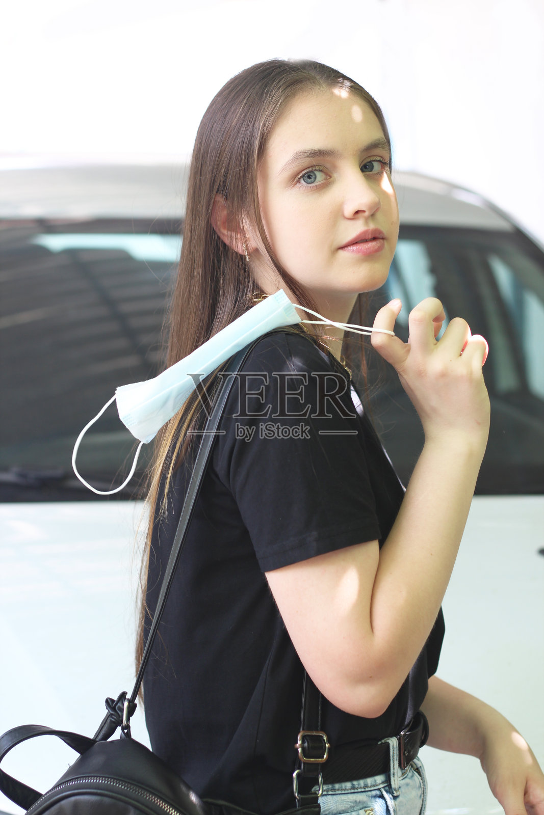 快乐的小女孩在街上摘下医用口罩,一名妇女为冠状病毒大流行结束而高兴照片摄影图片