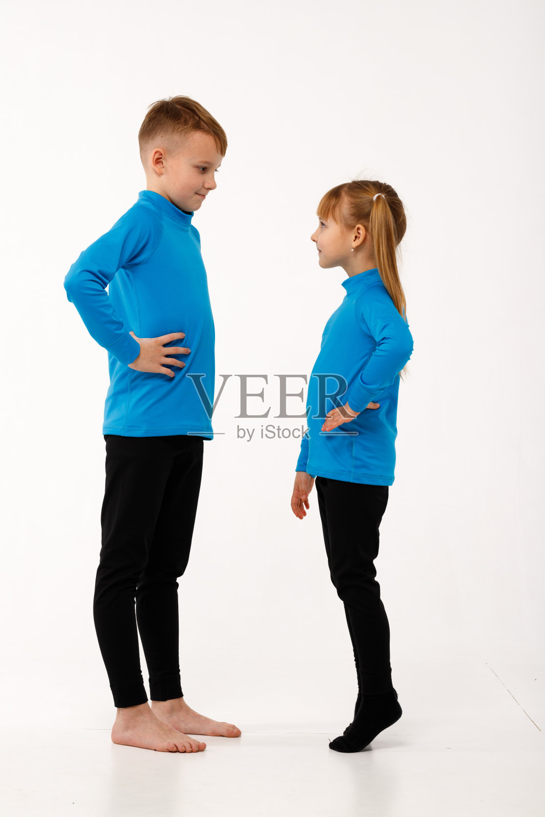 一个小女孩和她哥哥穿着保暖服。照片摄影图片