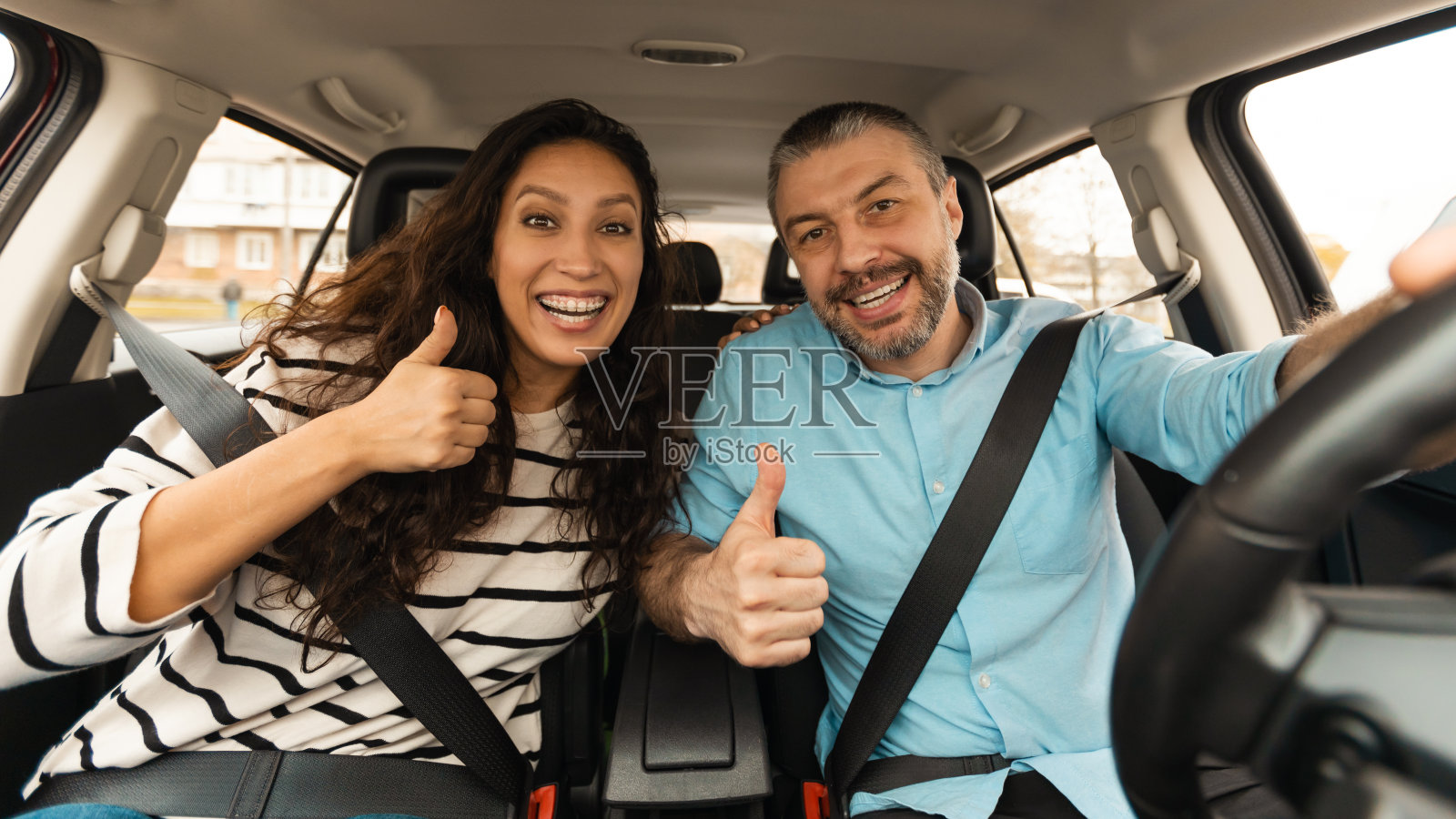 新婚夫妇坐在新车里竖起大拇指,全景图照片摄影图片