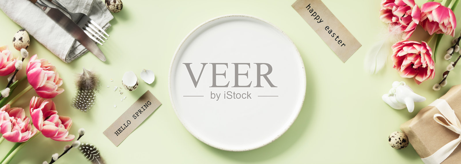 复活节餐桌上有白色的盘子,春天的鲜花和餐具。节日的背景照片摄影图片