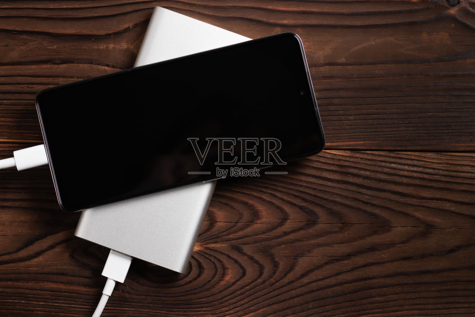 移动电源和充电智能手机在木桌上照片摄影图片