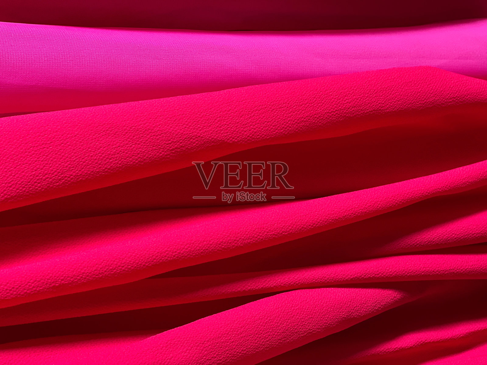 亮粉红色真丝面料背景。照片摄影图片