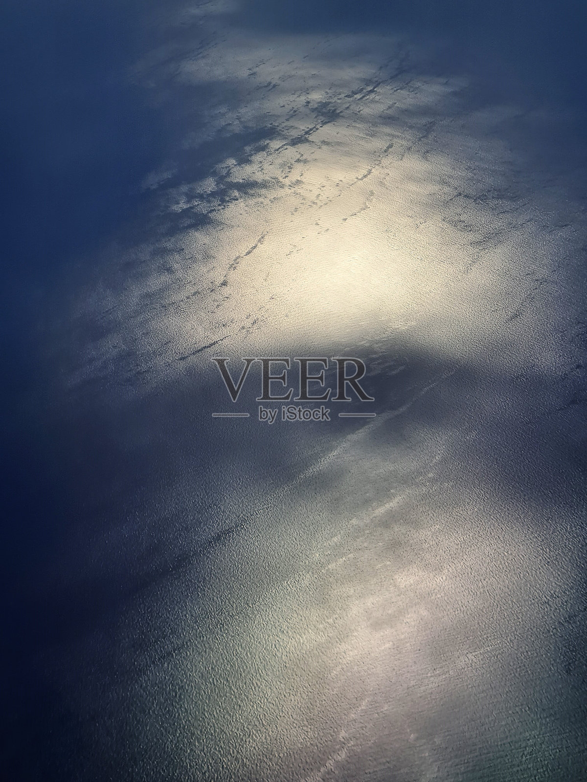 从飞机上看到的背光下的大海照片摄影图片