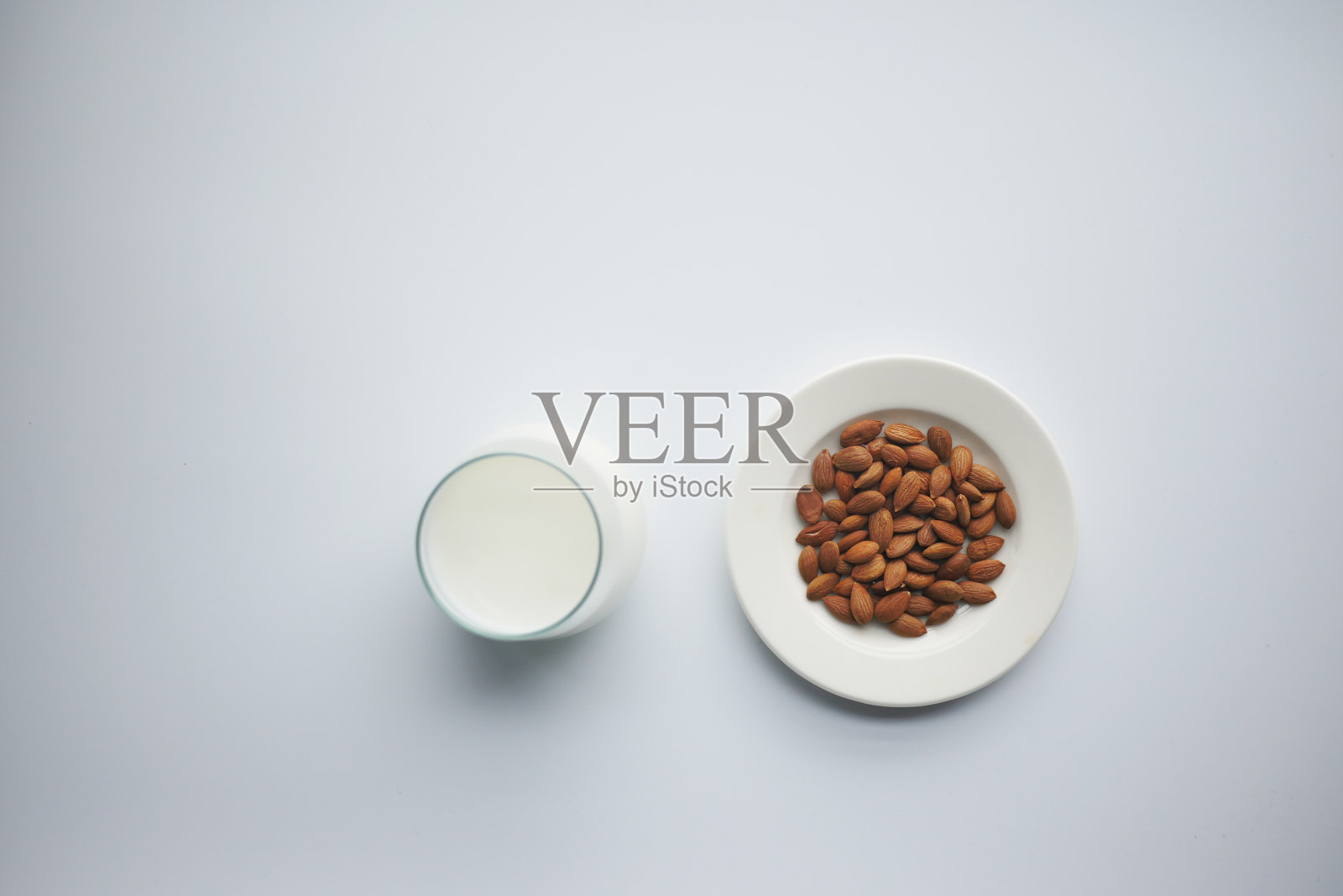 顶部视图杏仁坚果和牛奶的白色背景照片摄影图片