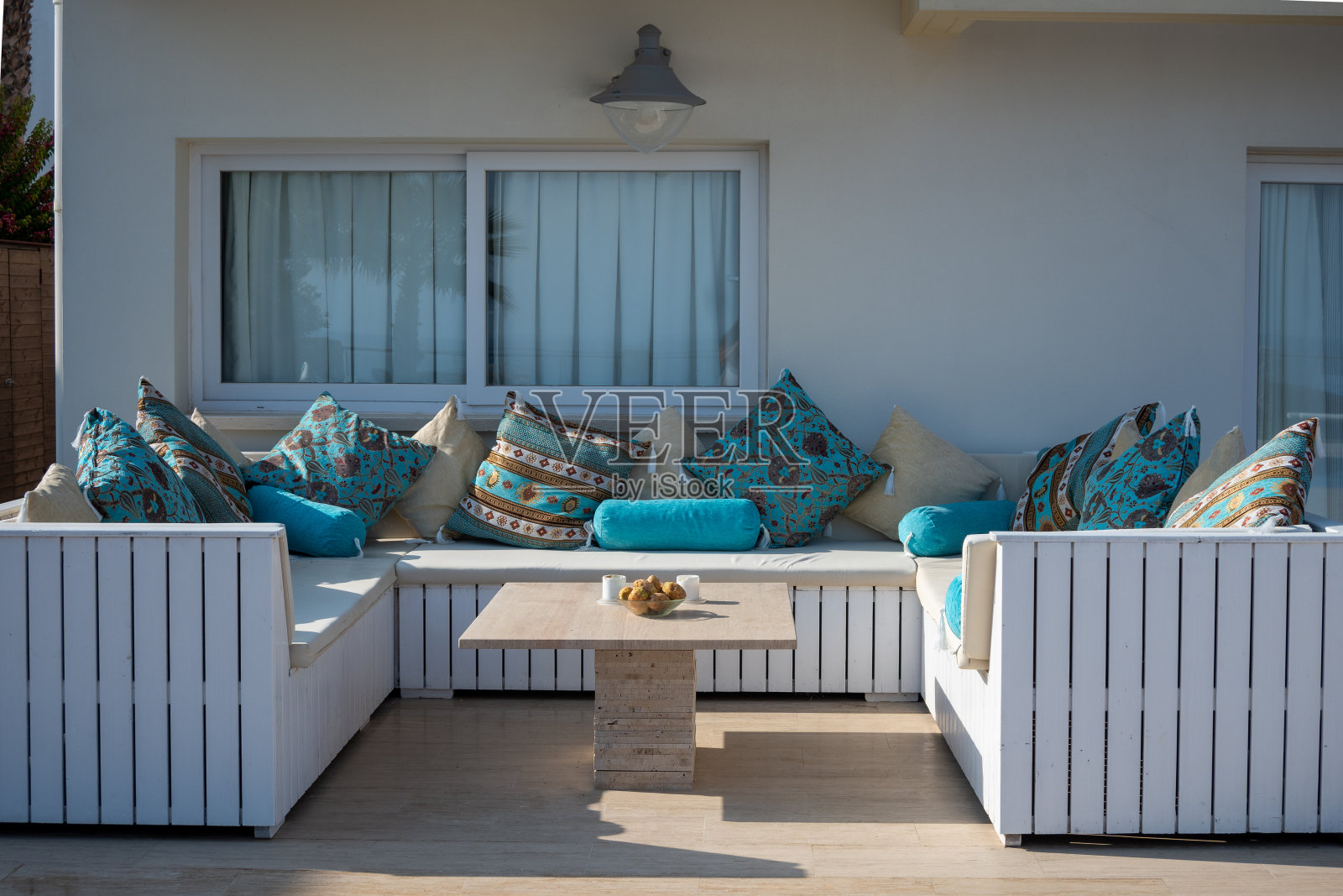 白色别墅墙与东方风格的白色木制露台家具和舒适的绿松石靠垫照片摄影图片