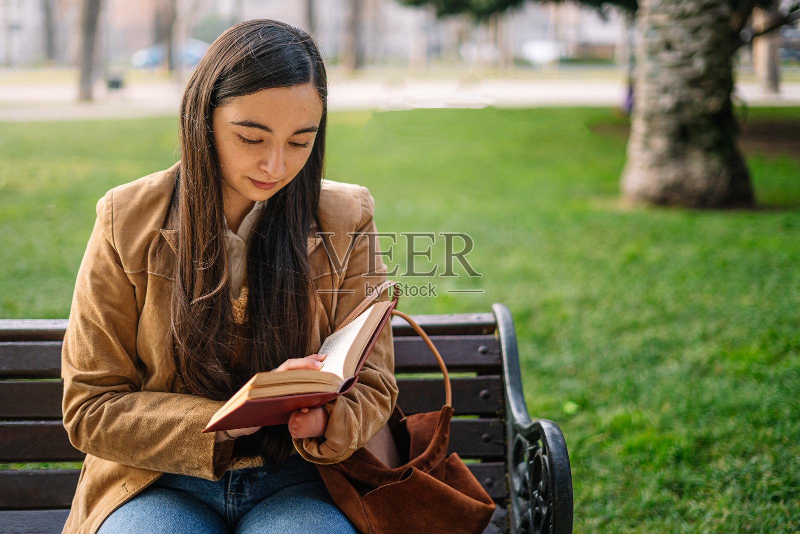 一个女孩坐在公园长椅上的特写照片摄影图片
