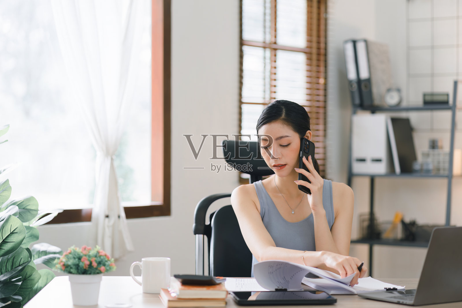 一个快乐的千禧亚洲女商人的肖像从她的家庭办公室远程工作。照片摄影图片