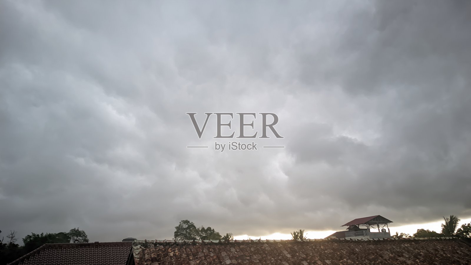 多云的天空和乌云的状况是下雨的迹象,在一个居民区和许多行树,东南亚照片摄影图片