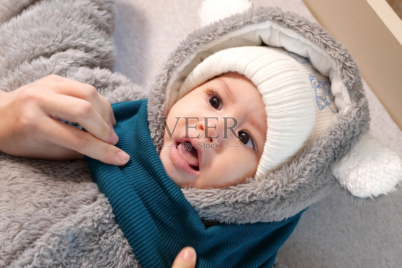 一位母亲在家里给她的小男孩穿衣服。童年为人父母,成长为家庭观念真实的人照片摄影图片