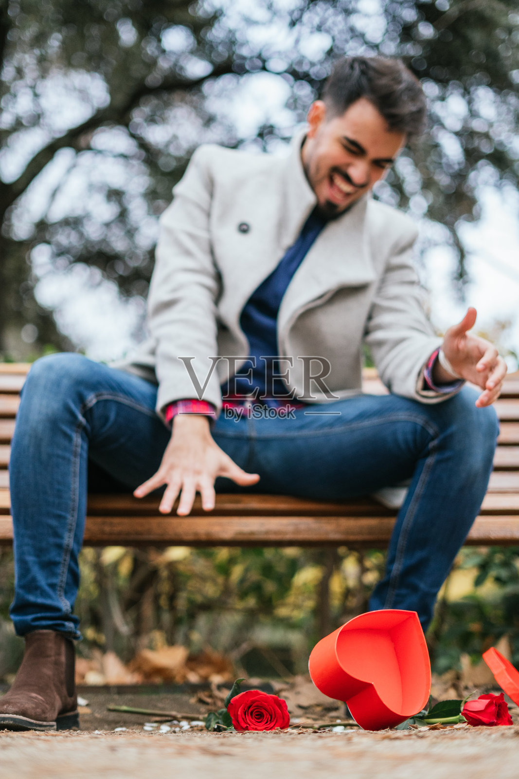 一个年轻男性将礼物盒扔在地上的浅焦镜头照片摄影图片