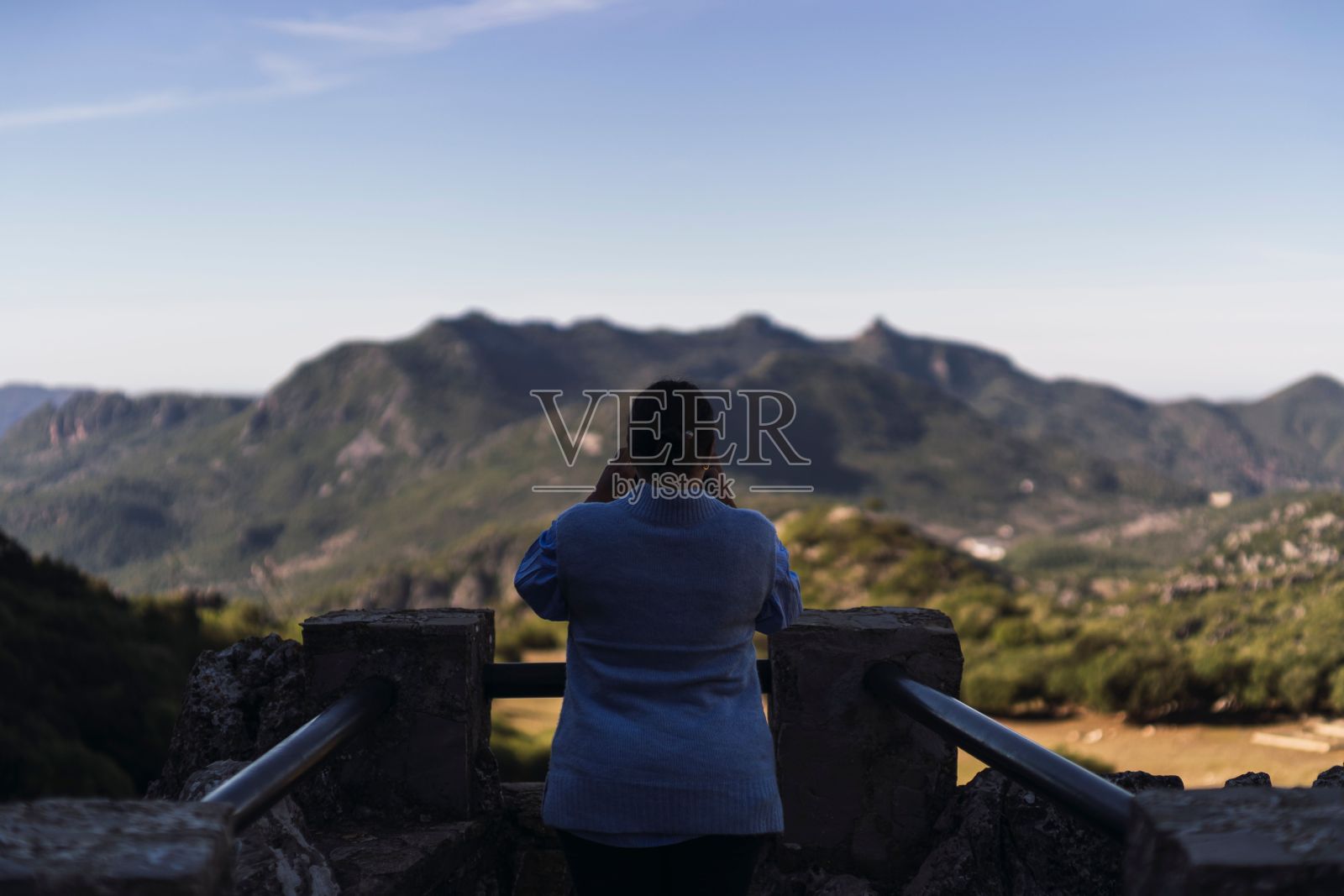 一名女游客在安达卢西亚加的斯的格拉扎莱马拍摄山脉照片的背影照片摄影图片