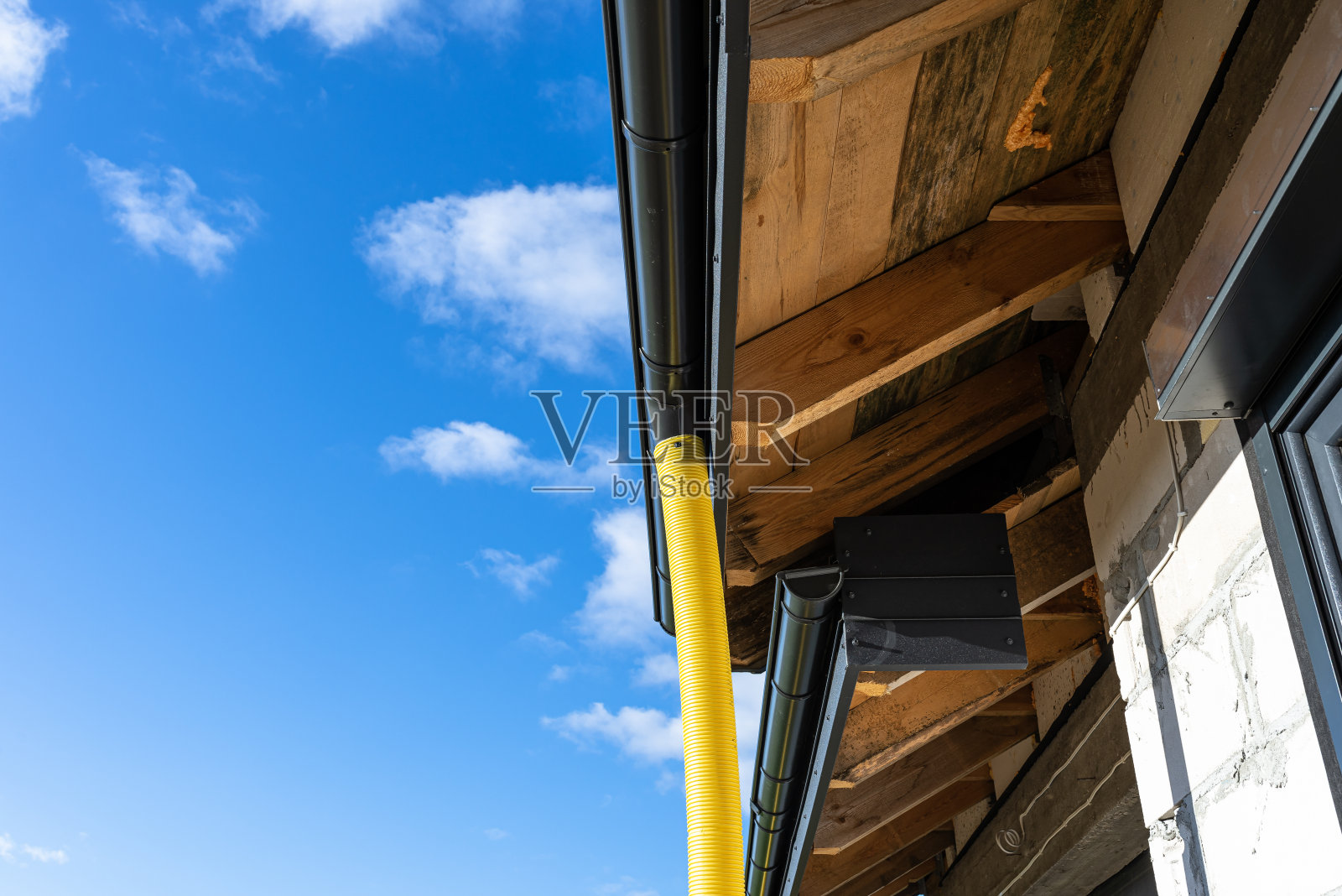 直径100mm的黄色PVC管连接到天沟的末端,防水。照片摄影图片