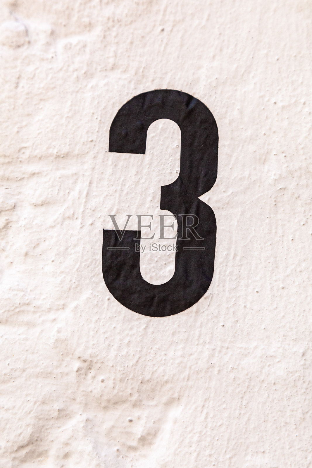 3数字装饰字体用黑色油漆手绘在白色油漆水泥渲染的房子墙壁上。照片摄影图片