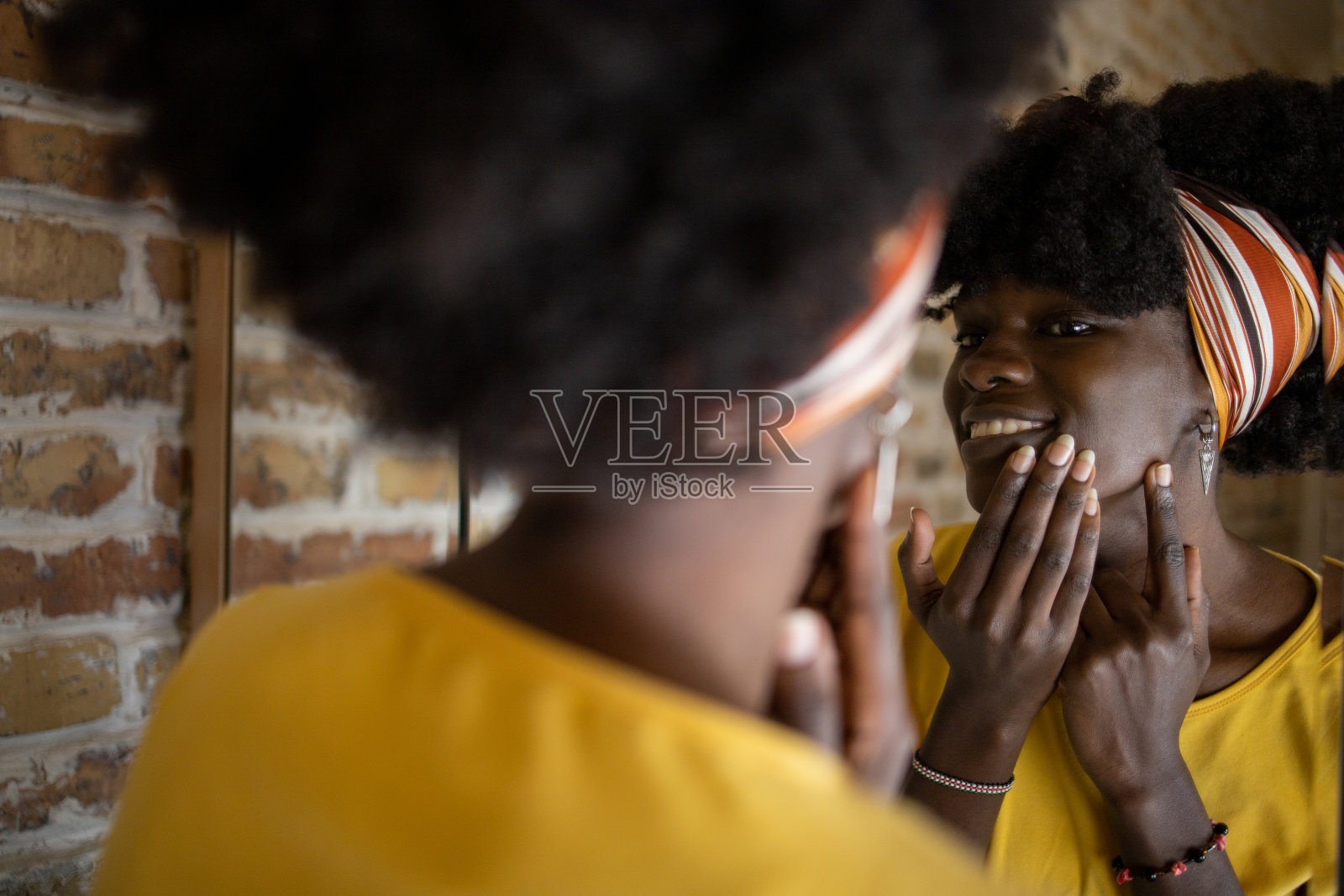 一个漂亮的女人在他脸上涂保湿霜照片摄影图片