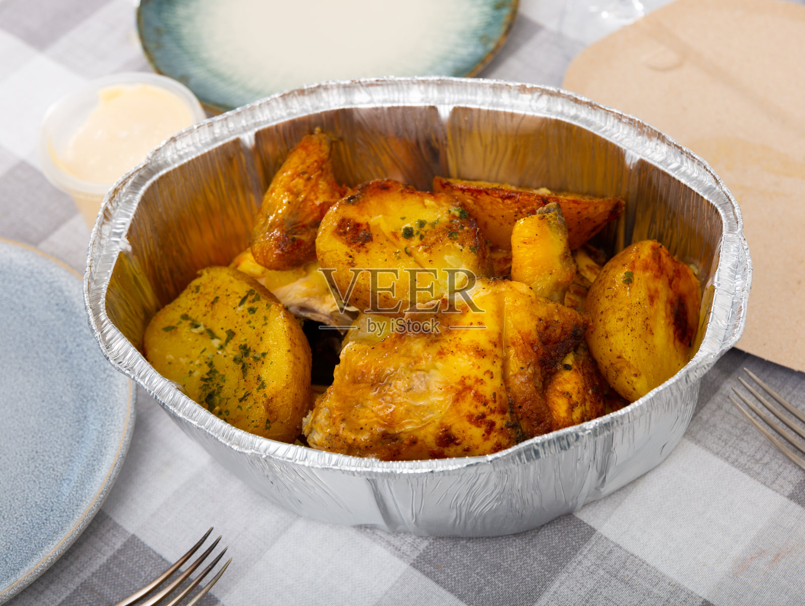 烤鸡和烤土豆装在箔纸里照片摄影图片