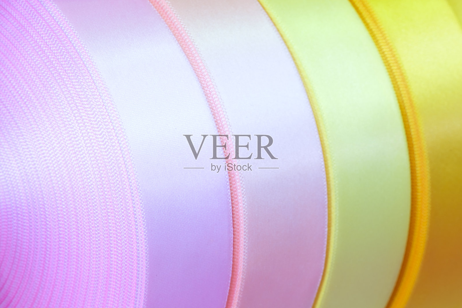 一组多卷不同颜色的缎带,用于标签或装饰特写,作为纹理背景照片摄影图片