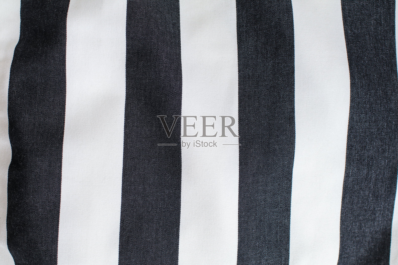 条纹褶皱的黑白一块布作为织物的背景纹理。现代时尚的壁纸。照片摄影图片