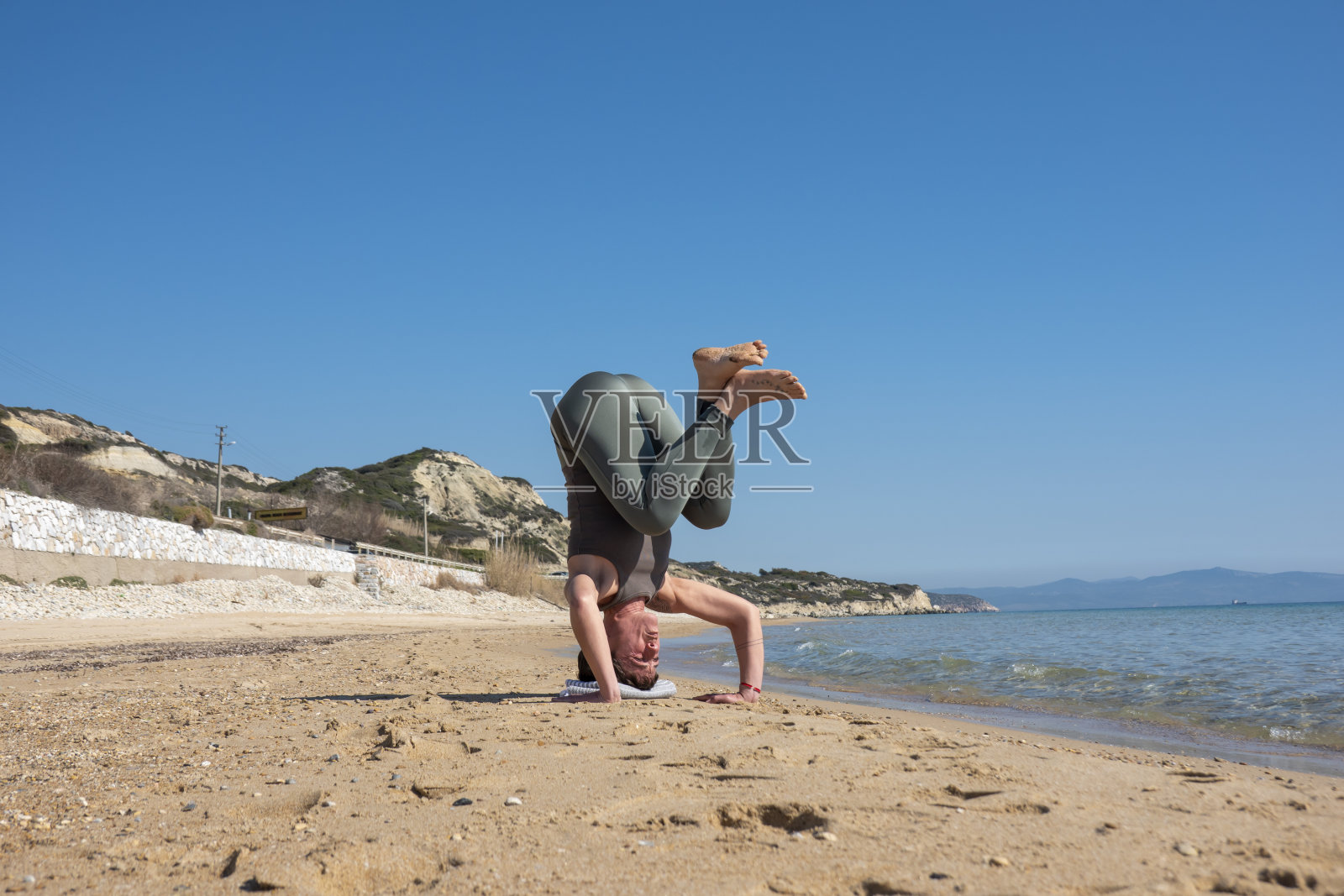 一名女子在海滩上练习瑜伽照片摄影图片