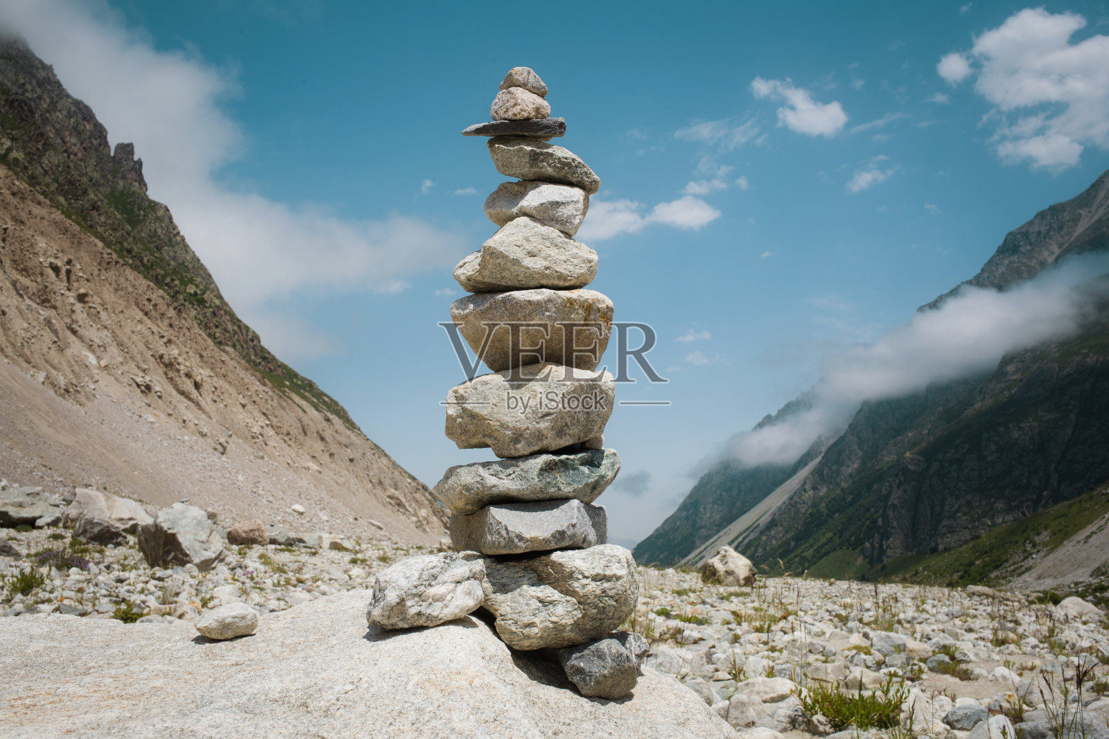 山体景观背景下的石头金字塔。夏季旅游路线照片摄影图片
