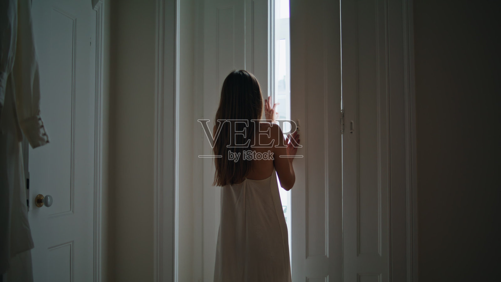 温柔的女士在卧室打开百叶窗。放松的女人独自享受早晨照片摄影图片