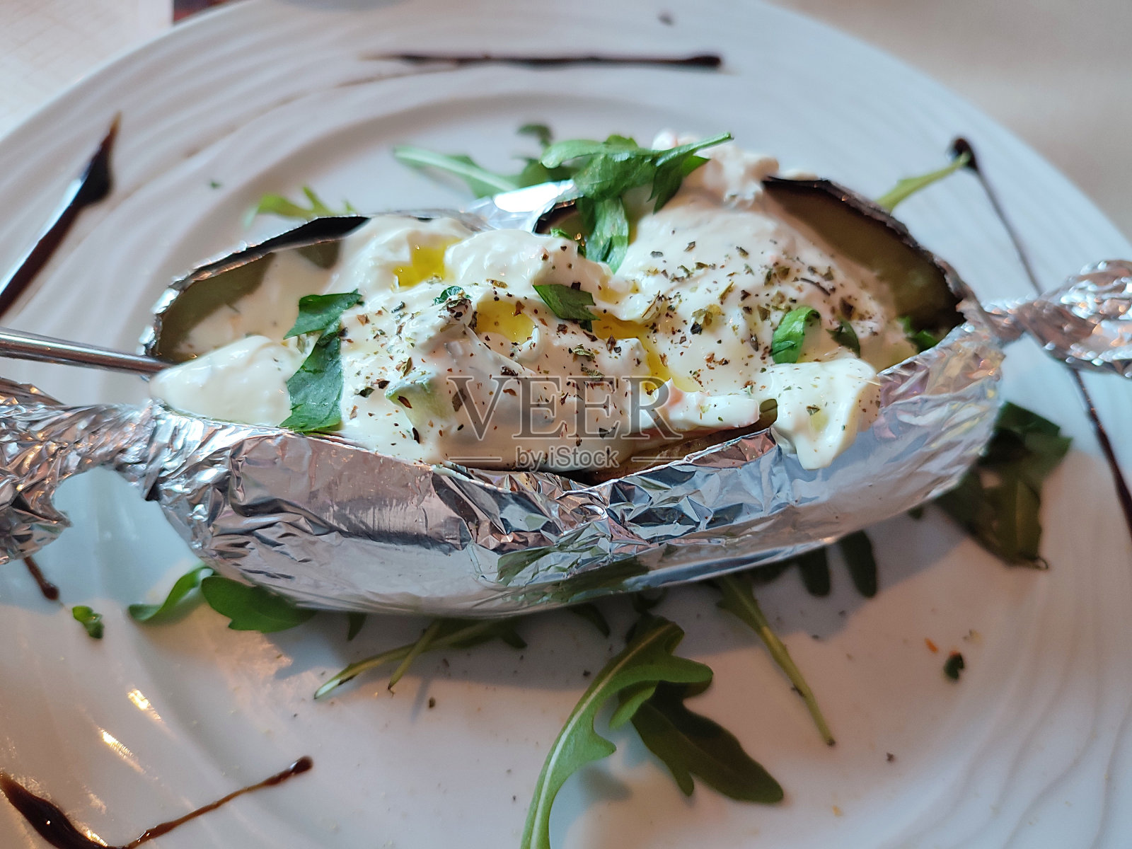 一个盘子的特写,里面有烤土豆和铝箔酸奶油照片摄影图片