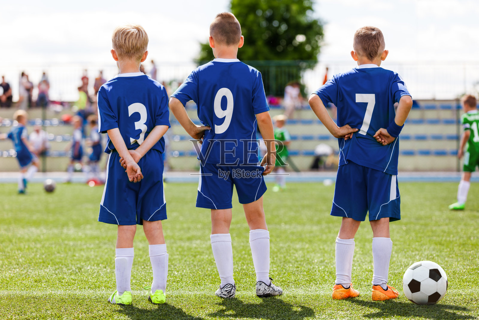 儿童足球比赛。孩子们在球场边等待。穿着足球运动服和球鞋的运动男孩照片摄影图片