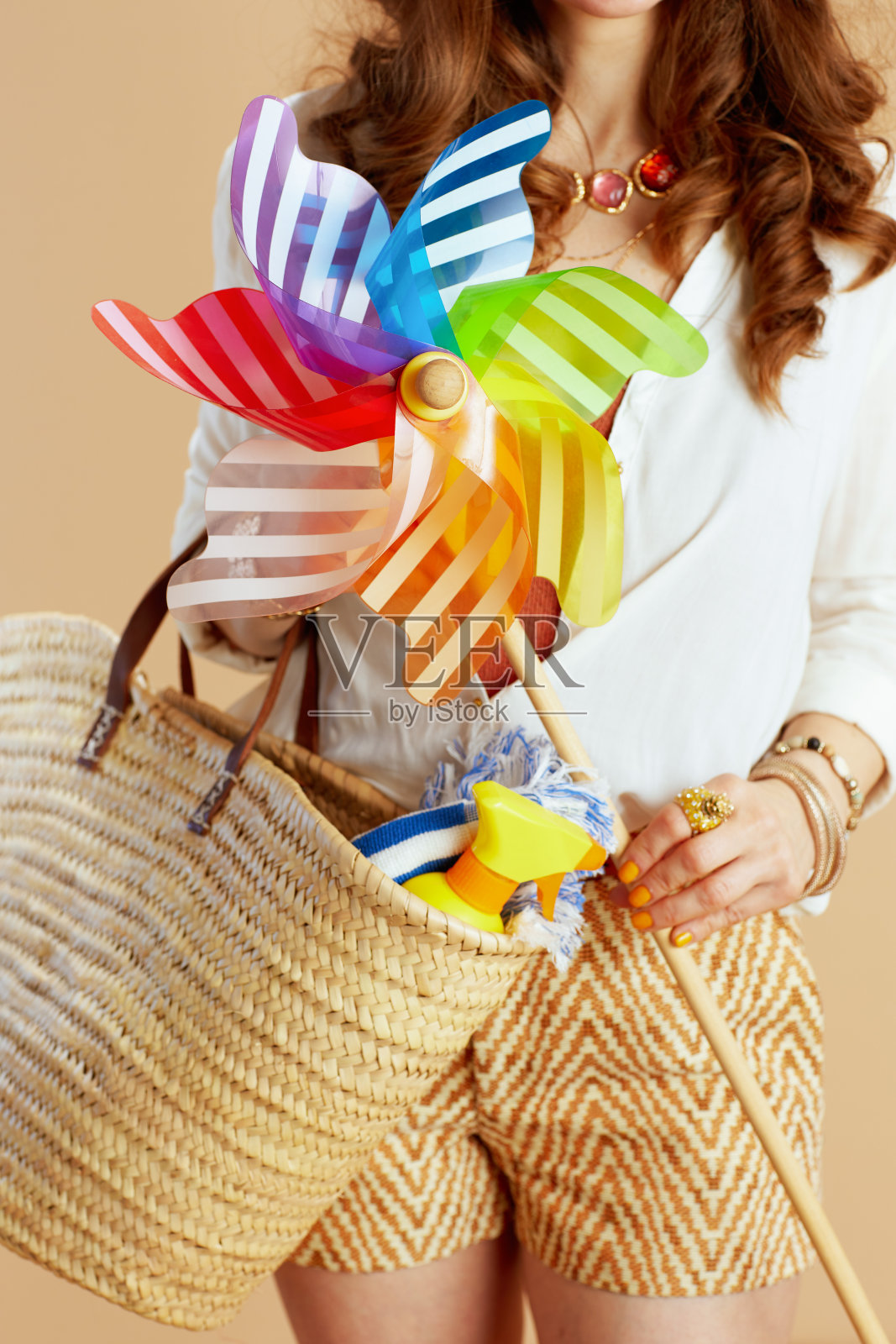 优雅的女人在衬衫和短裤风车玩具米色照片摄影图片