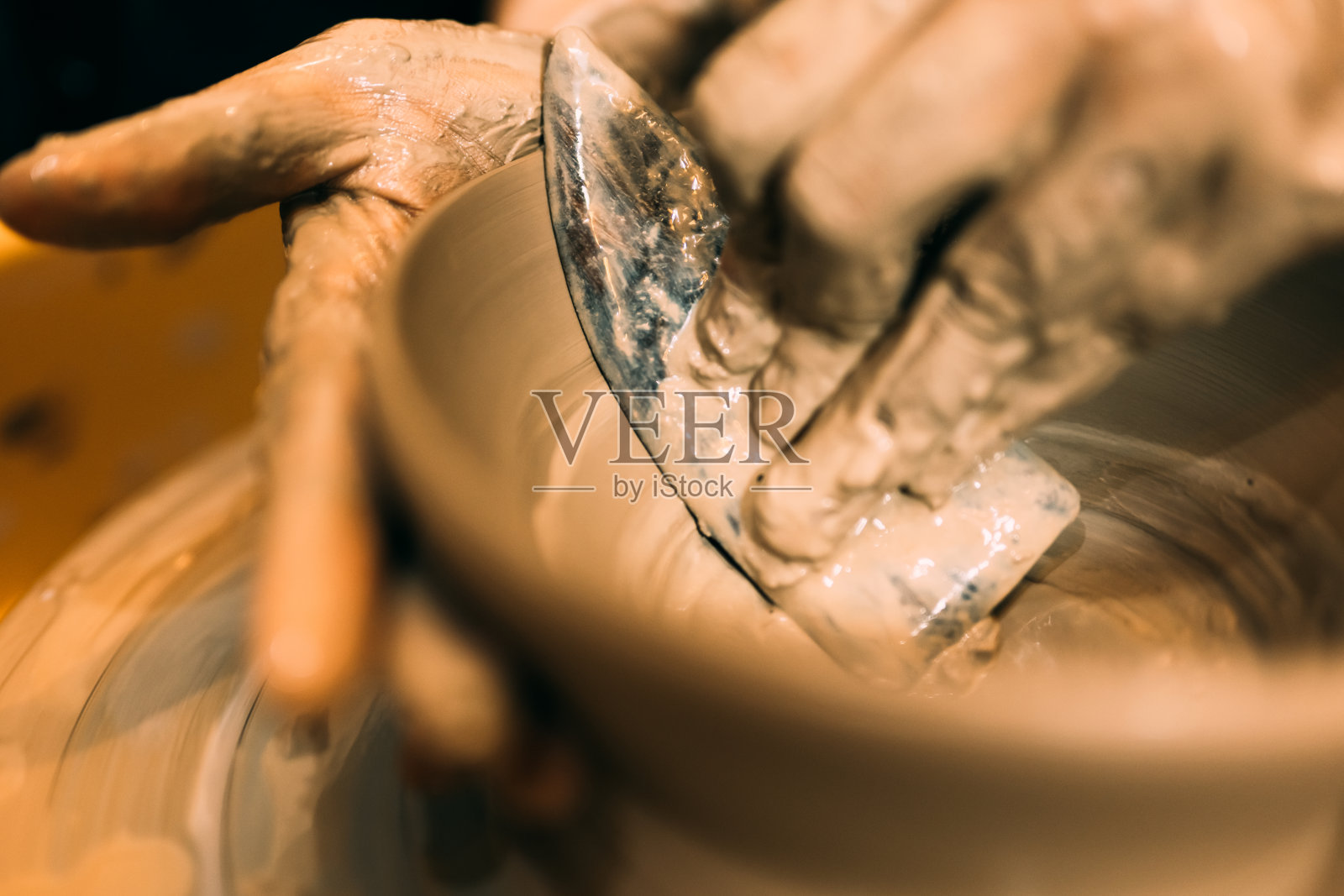 陶工在车间的陶轮圈上制作陶罐照片摄影图片