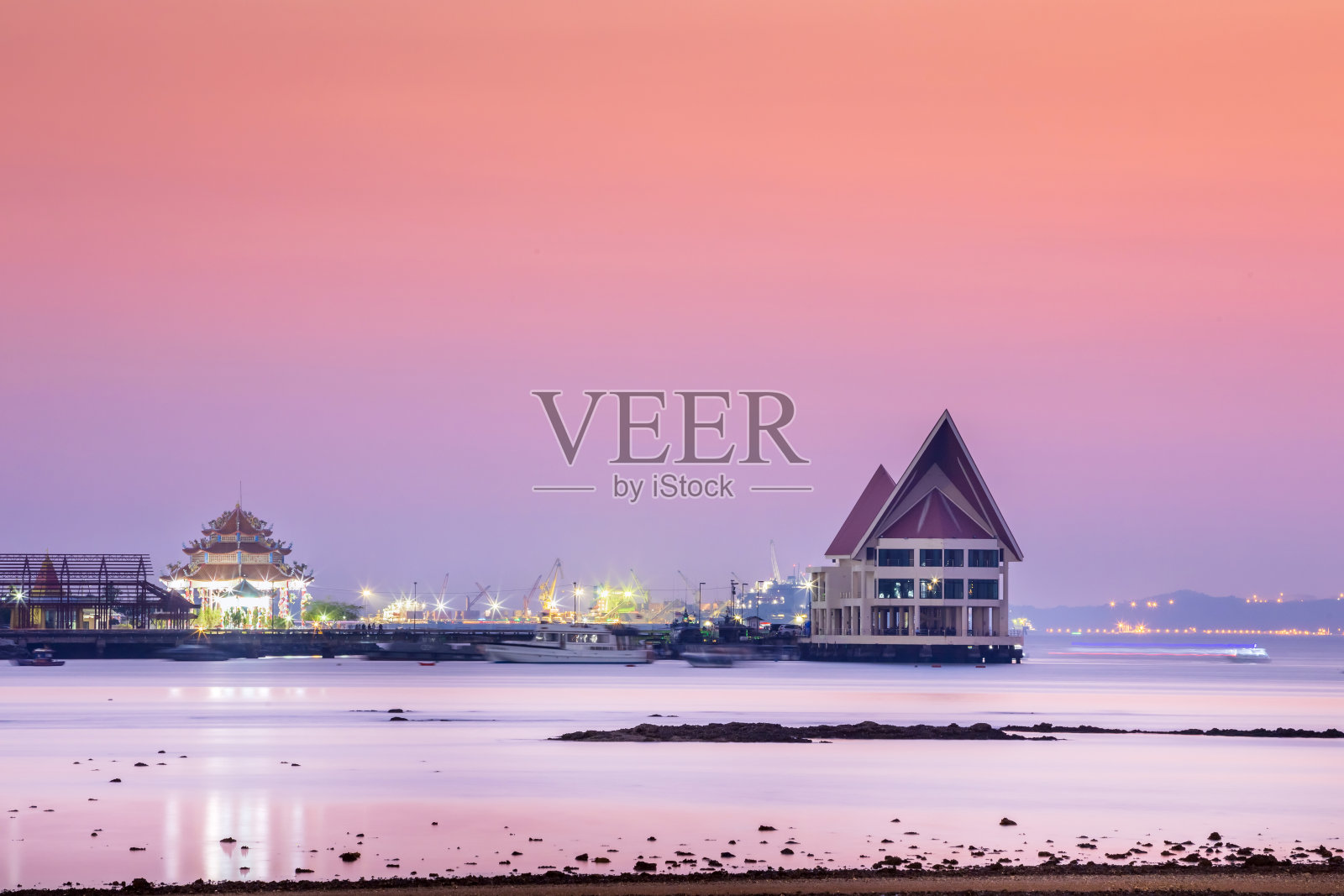 长曝光技术,因此运动模糊效果烟熏和柔软的海水表面与小岛命名为Koh Loy船岩石和商业船只集装箱货物在地平线日落照片摄影图片