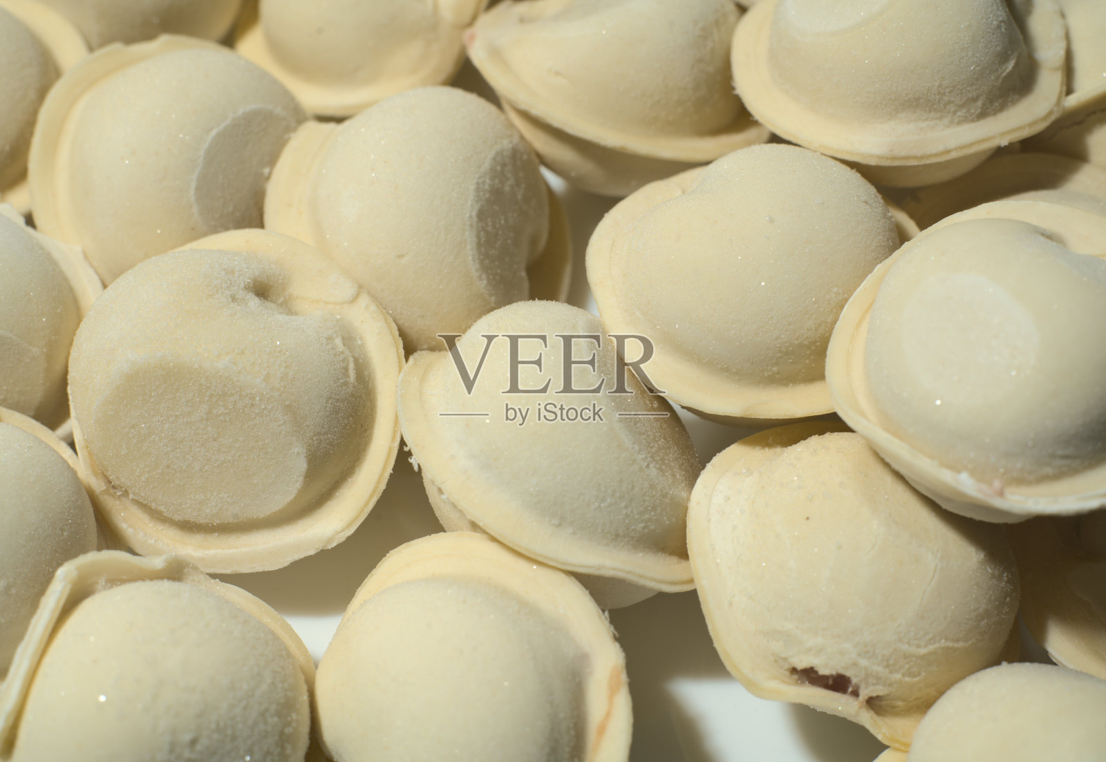 生冻饺子。特写镜头。饺子上有明显的霜冻照片摄影图片