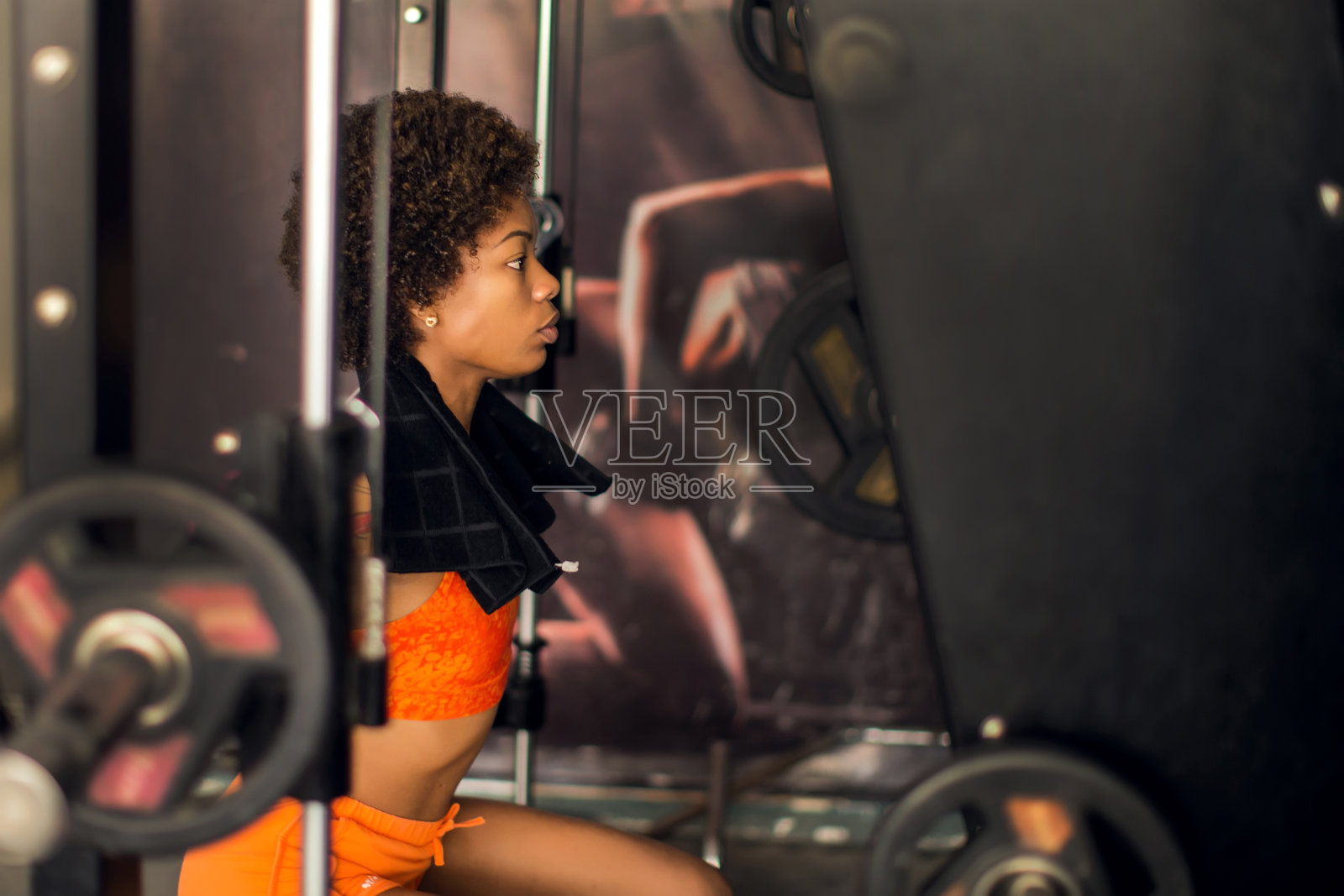 健身女性在健身房用动力架做杠铃后蹲。健康和生活方式的概念照片摄影图片