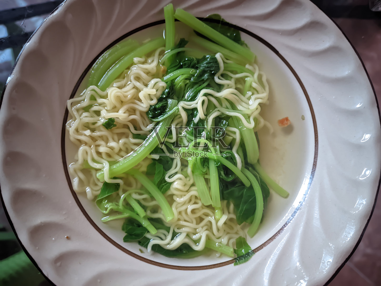 用菠菜煮熟的鸡肉味面汤趁热放在盘子里照片摄影图片