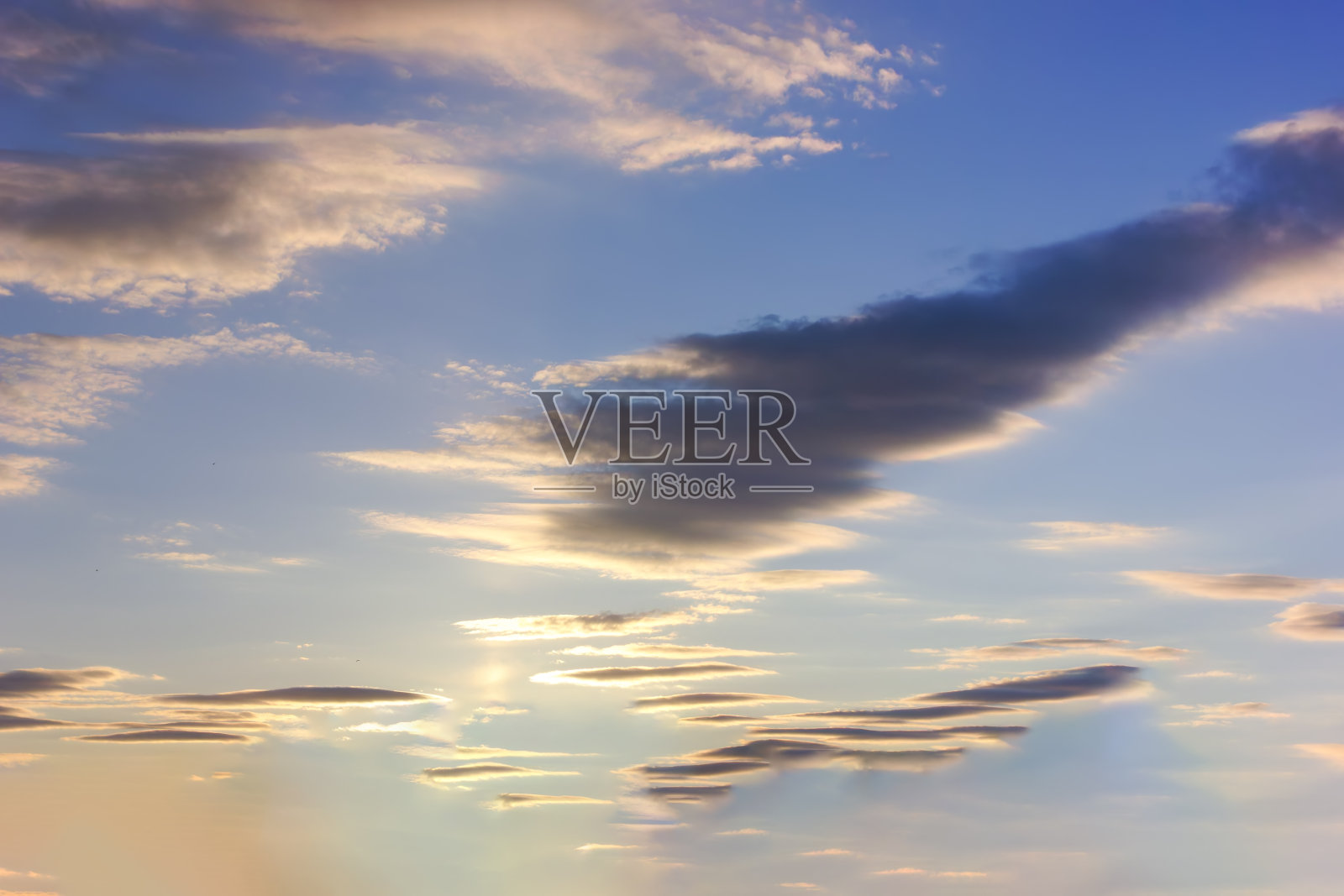 夏夜天空中如画的云彩,被落日的余晖照亮。照片摄影图片